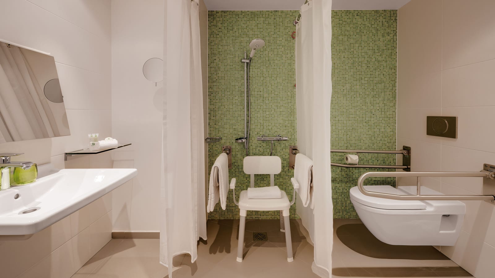 An accessible bathroom at Holiday Inn Frankfurt - Alte Oper with a roll-in shower and grab rails, one of three accessible rooms with barrier-free entry.